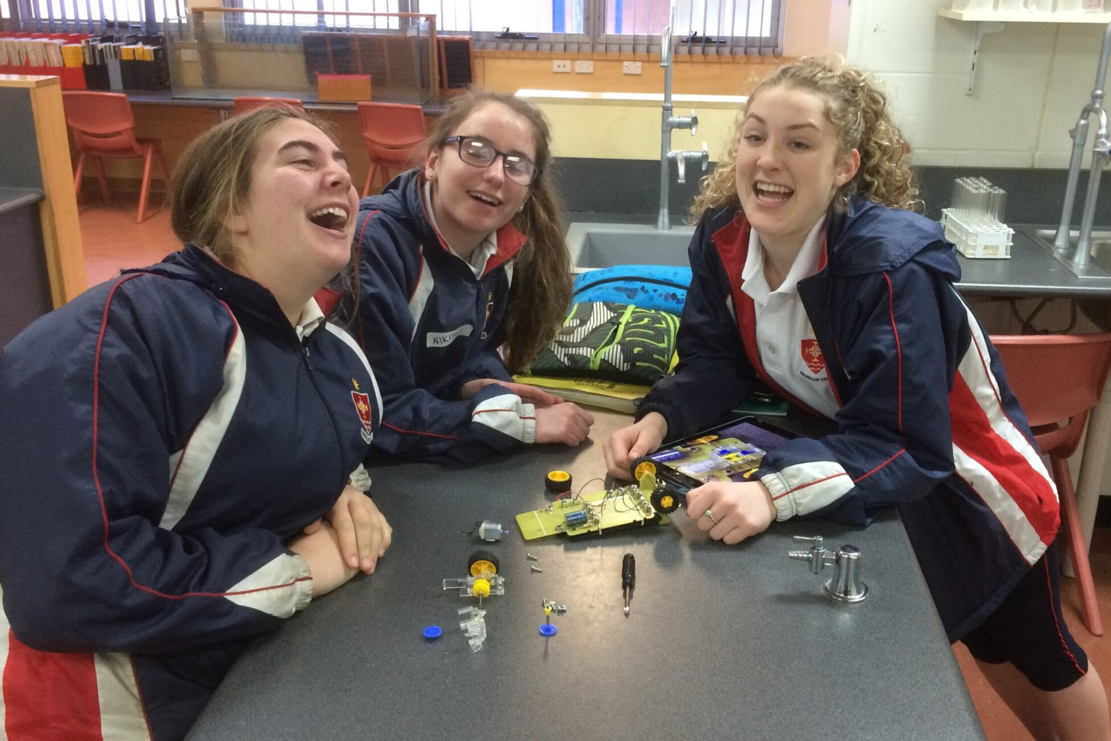 Three Laughing Female Students With Half Built Solar Car